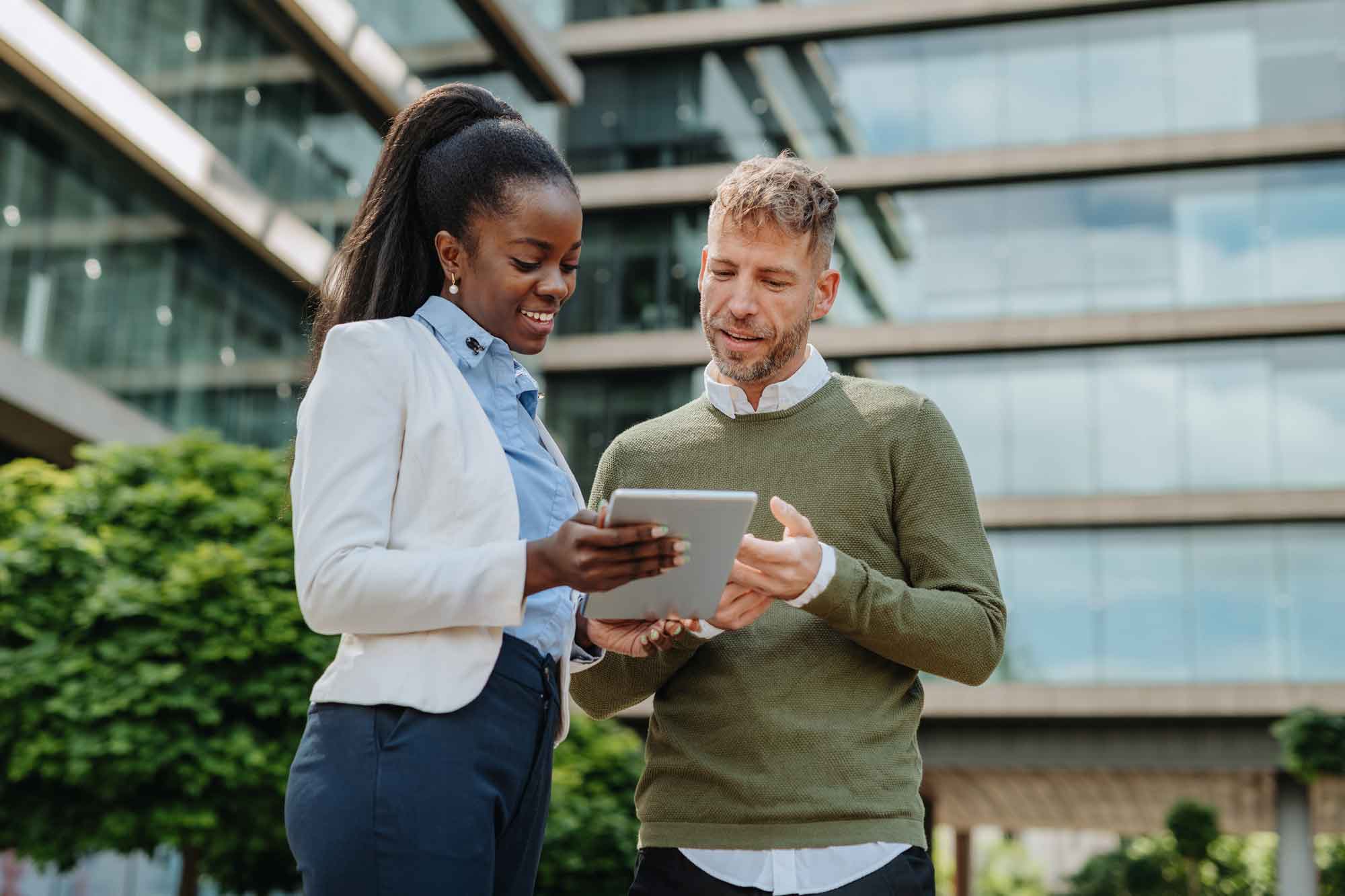 Business couple working on tablet outdoors