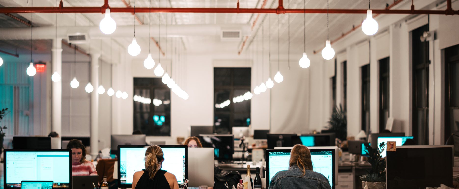 group of people using computers in an office