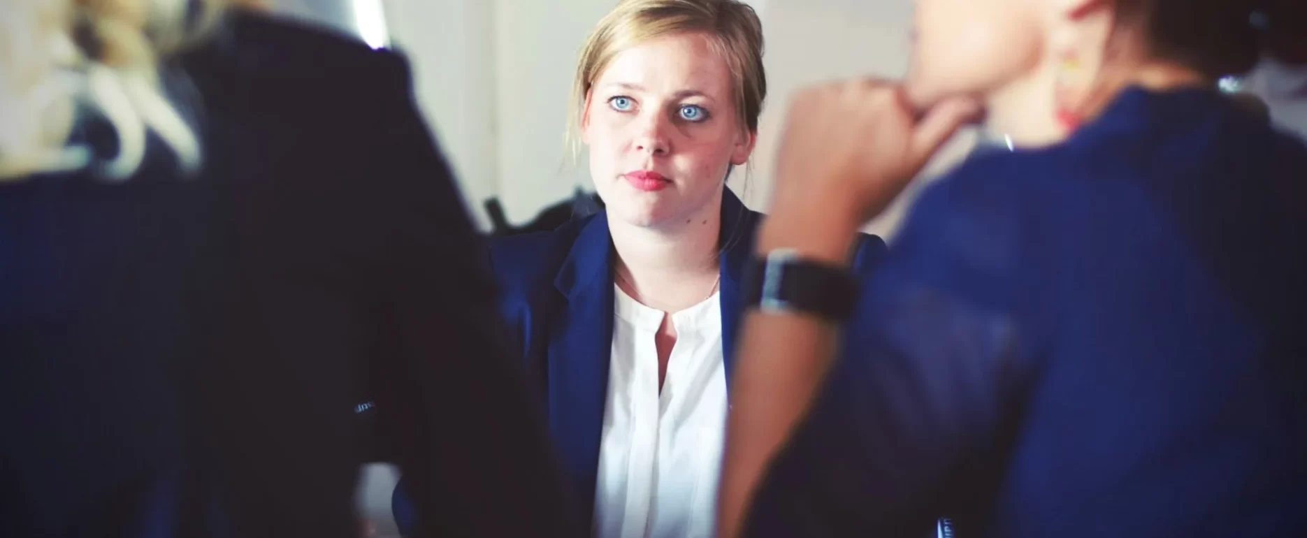 A woman engaged in conversation with two others at a table