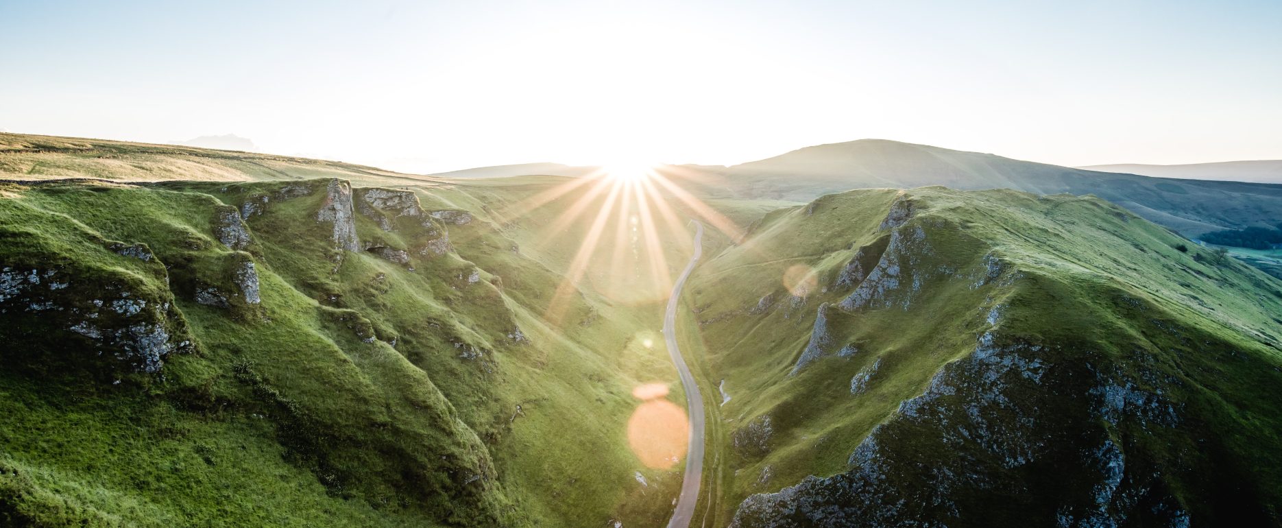 Sunlit winding road through picturesque mountains