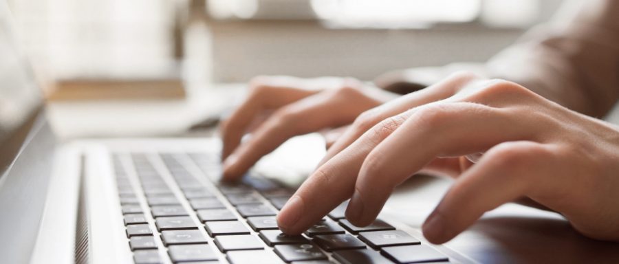 hands typing on a laptop keyboard