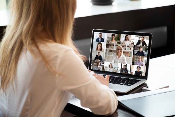 View over businesswoman shoulder during group video call