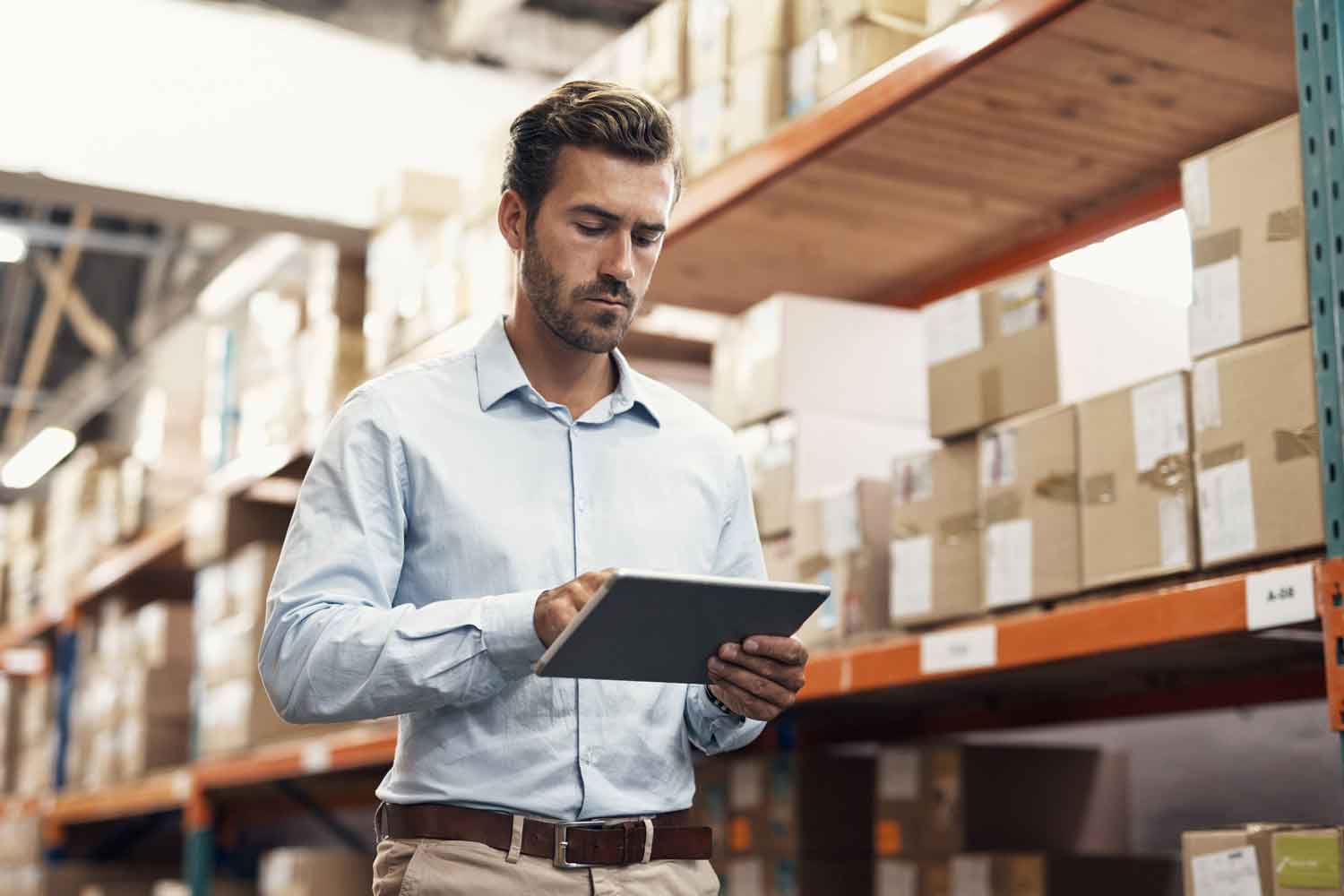 young man using a digital tablet while working in a warehouse