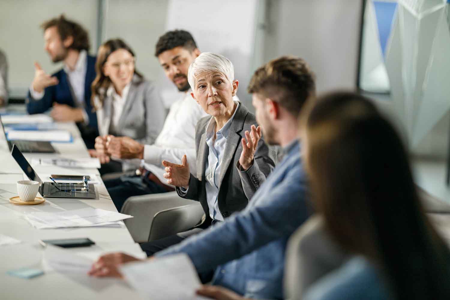 Mature businesswoman communicating with her colleagues on a meeting in the office