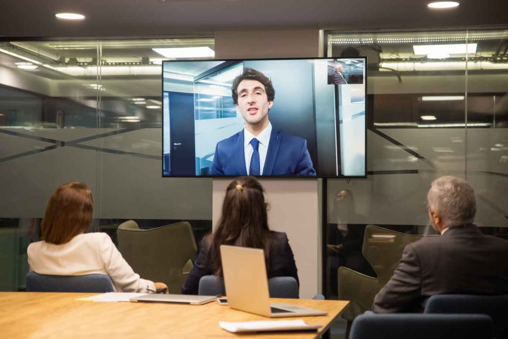 group of people listening to businessman during video conference