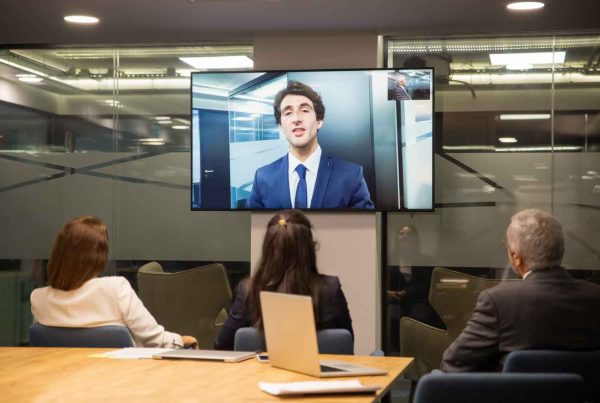 group of people listening to businessman during video conference