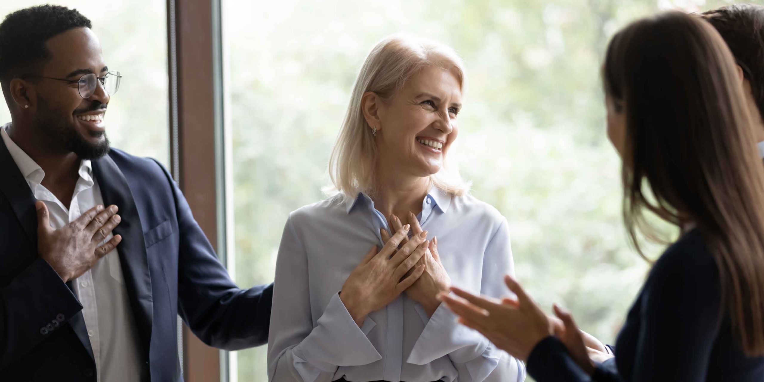 Middle-aged businesswoman get congrats and compliments from multiethnic colleagues