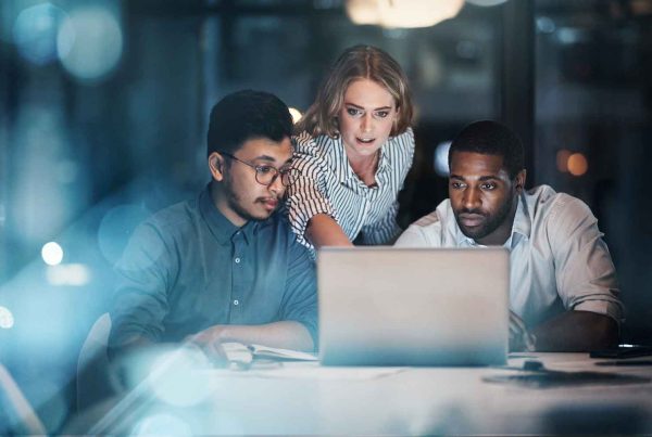 three young business people working together on a laptop in their office