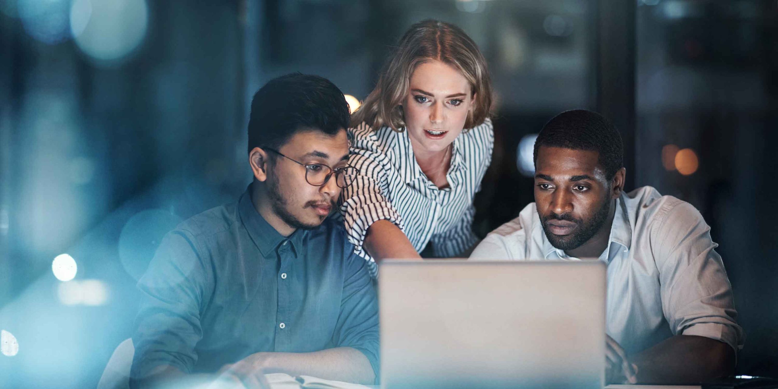 three young business people working together on a laptop in their office