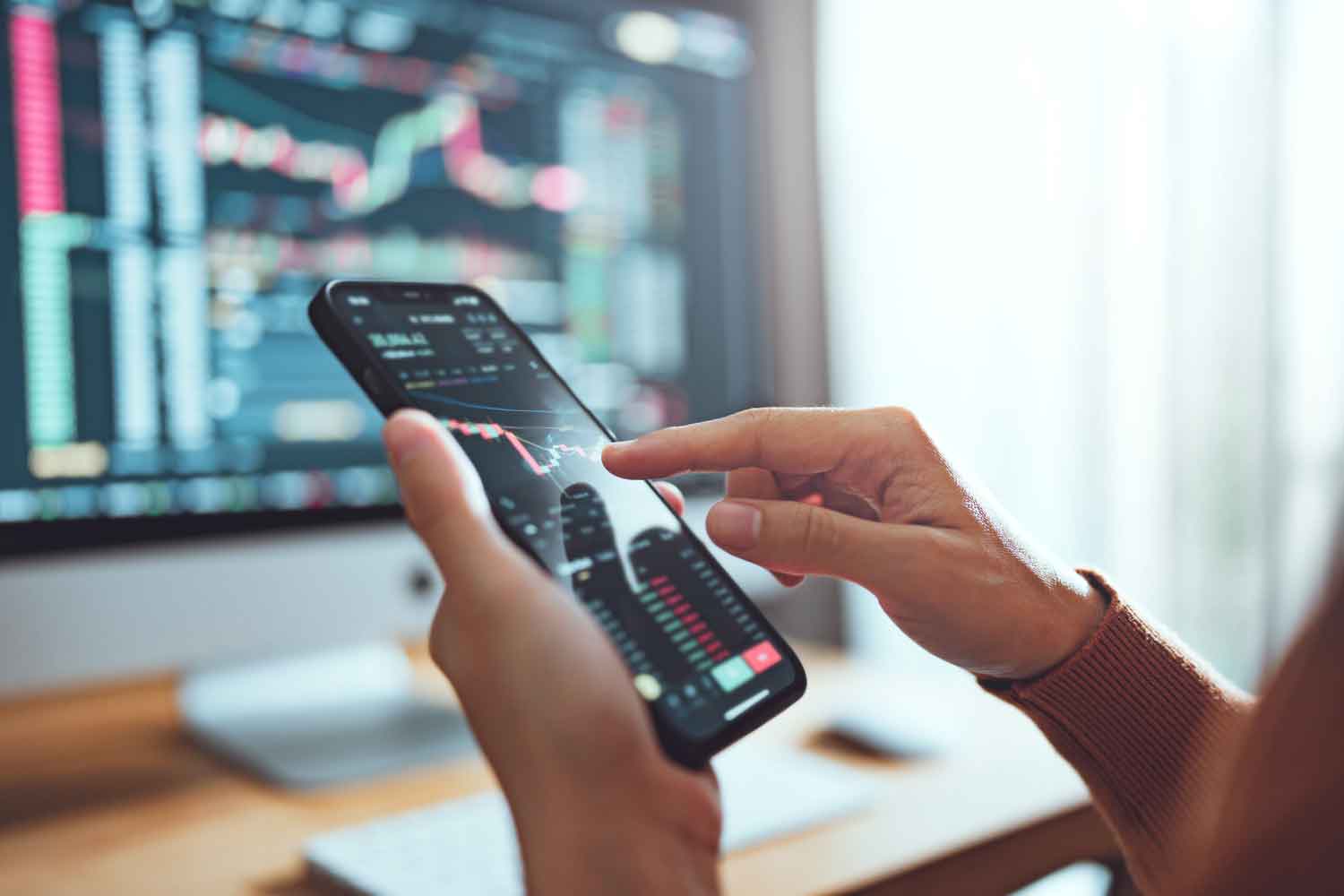 Closeup - Woman checking exchange marked on computer and smartphone