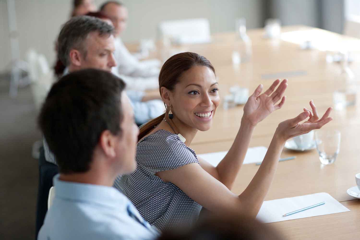 Smiling businesswoman gesturing in meeting in conference room