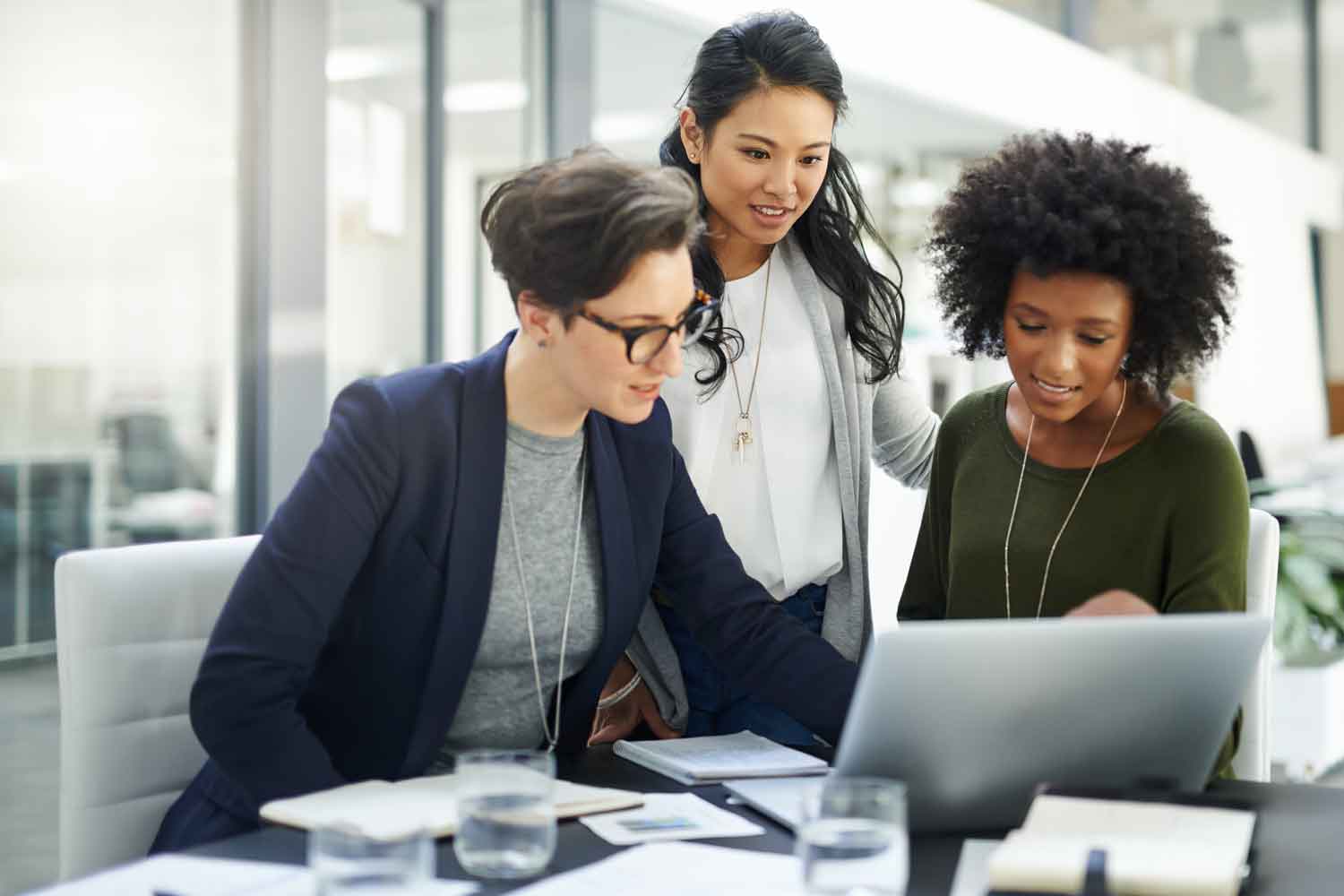 Shot of a group of businesswomen using a laptop during a meeting at work