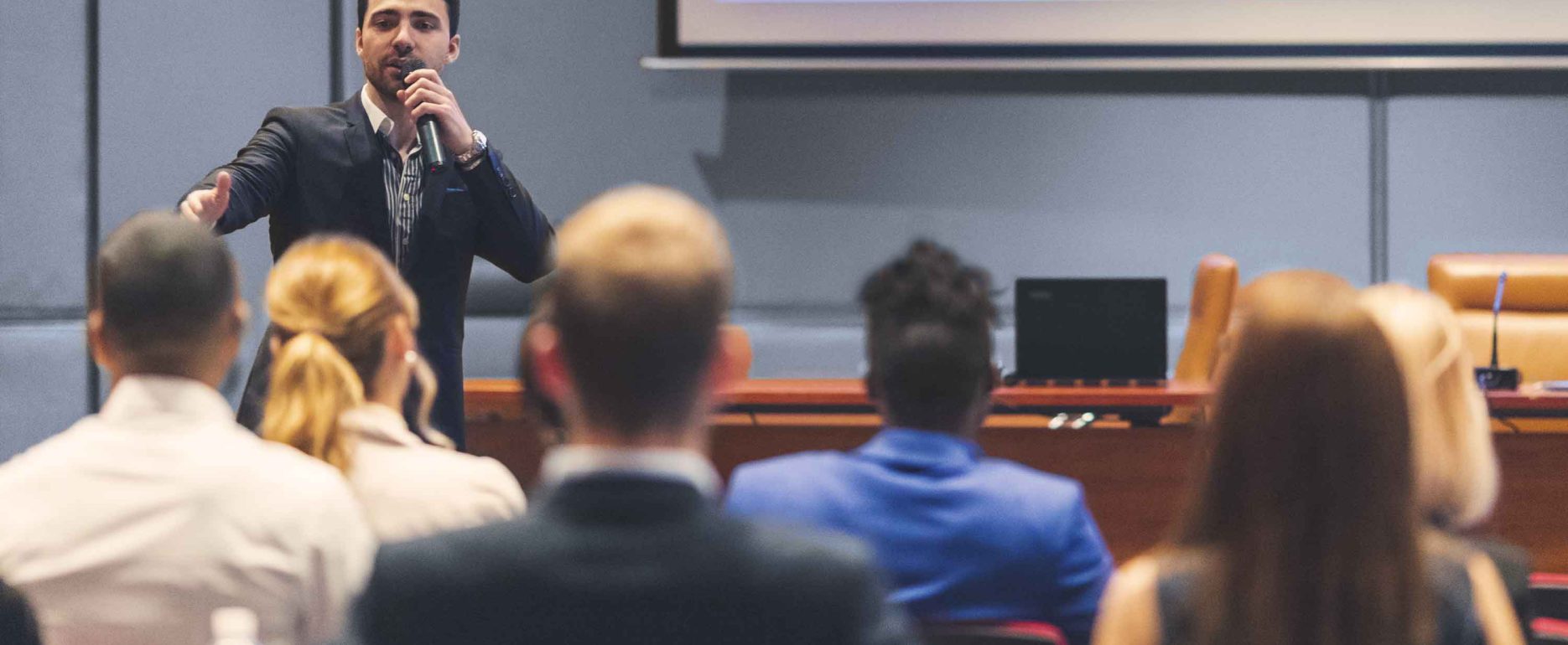 A presenter interacting with the audience at a business presentation in the board room