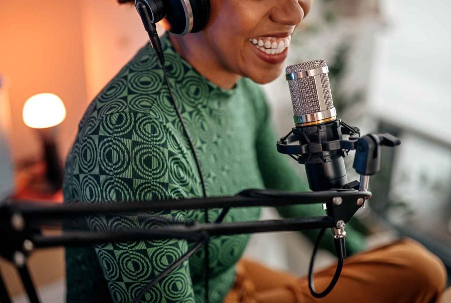 Closeup - young smiling women recording podcast and doing live streaming using microphone